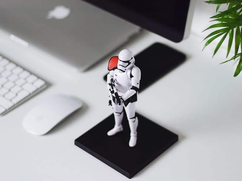 stormtrooper action figure standing next to a computer